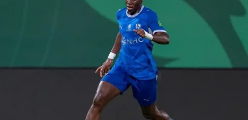 Player in blue kit dribbling soccer ball on field