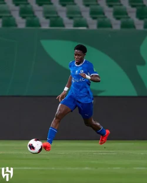 Player in blue kit dribbling soccer ball on field