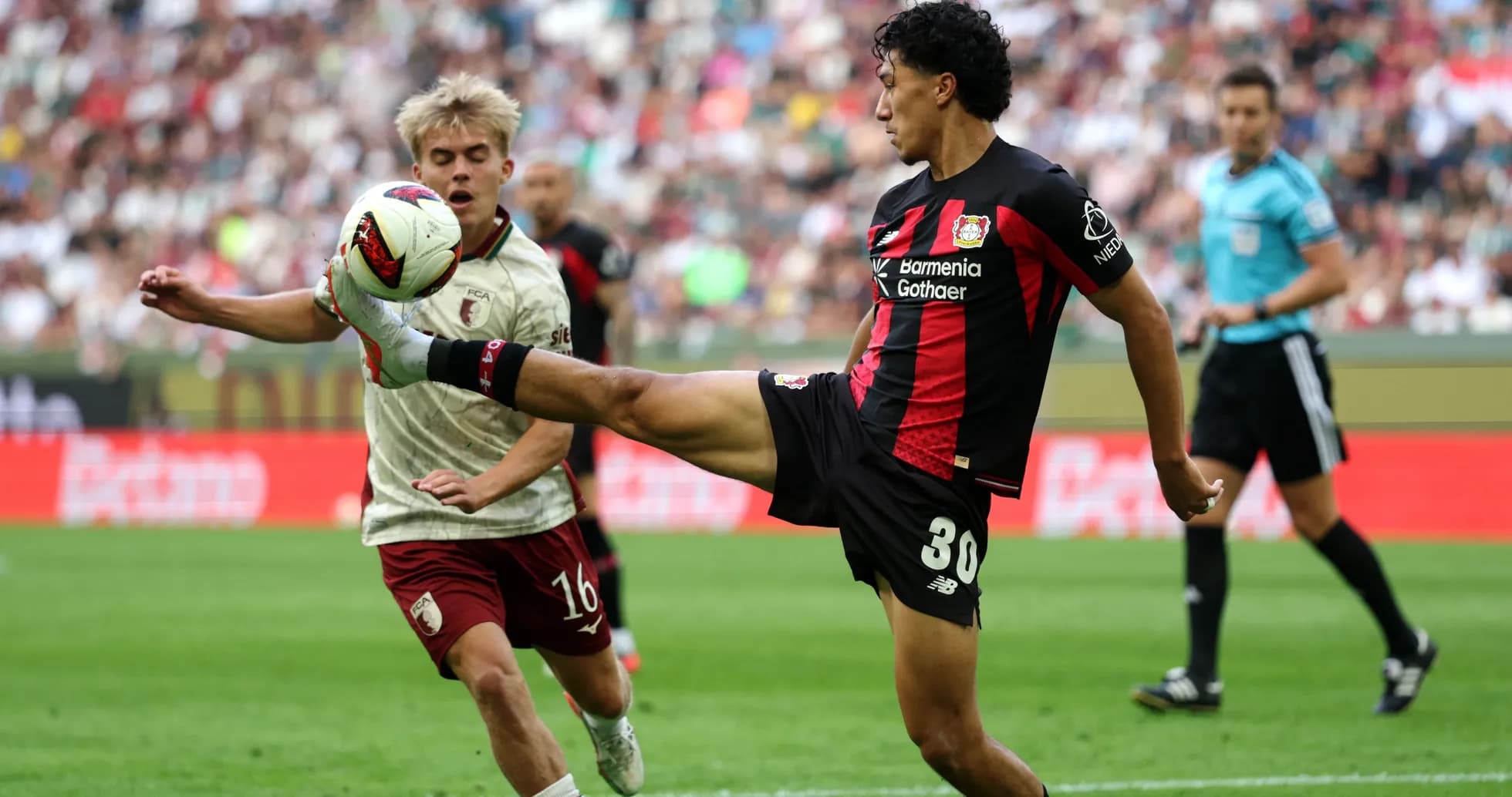 Player kicking ball while opponent defends during match