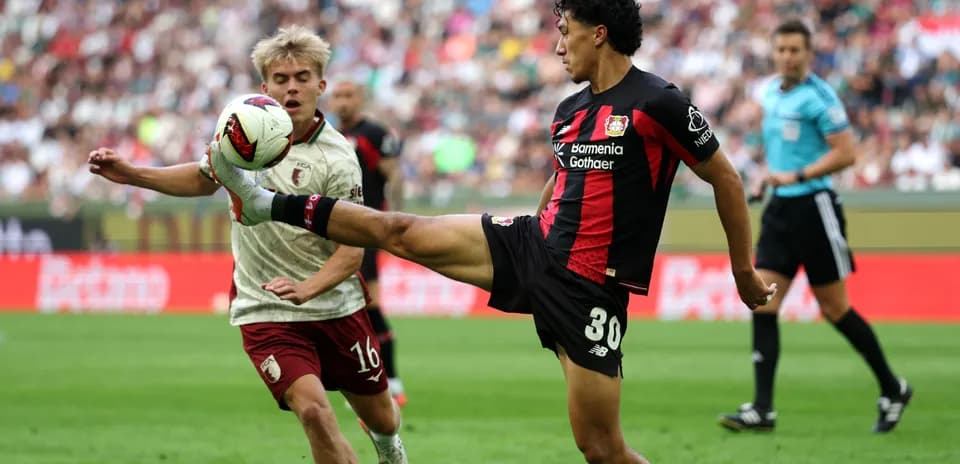 Player kicking ball while opponent defends during match
