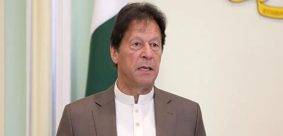 Man speaking at podium with Pakistan flag in background