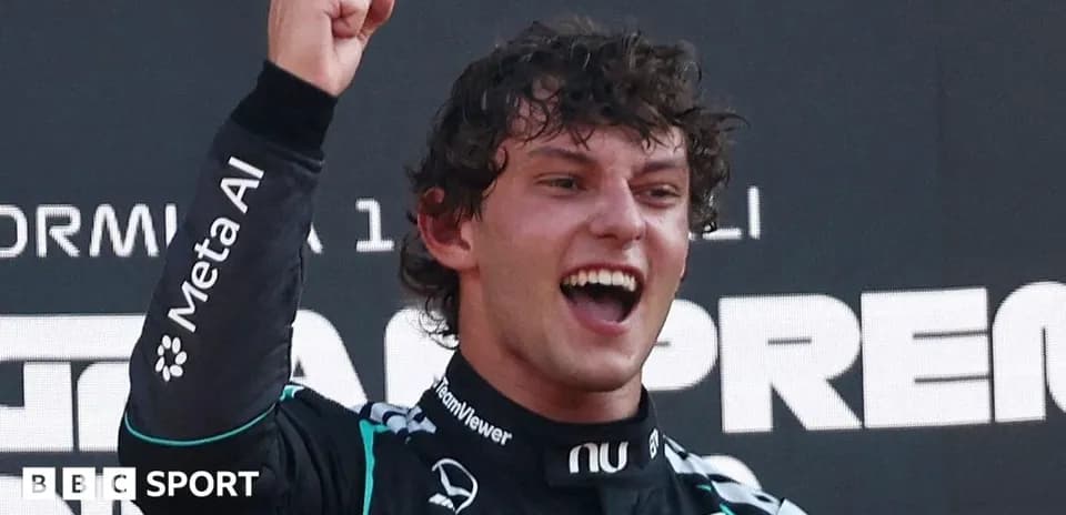 Driver celebrating victory on podium with raised fist