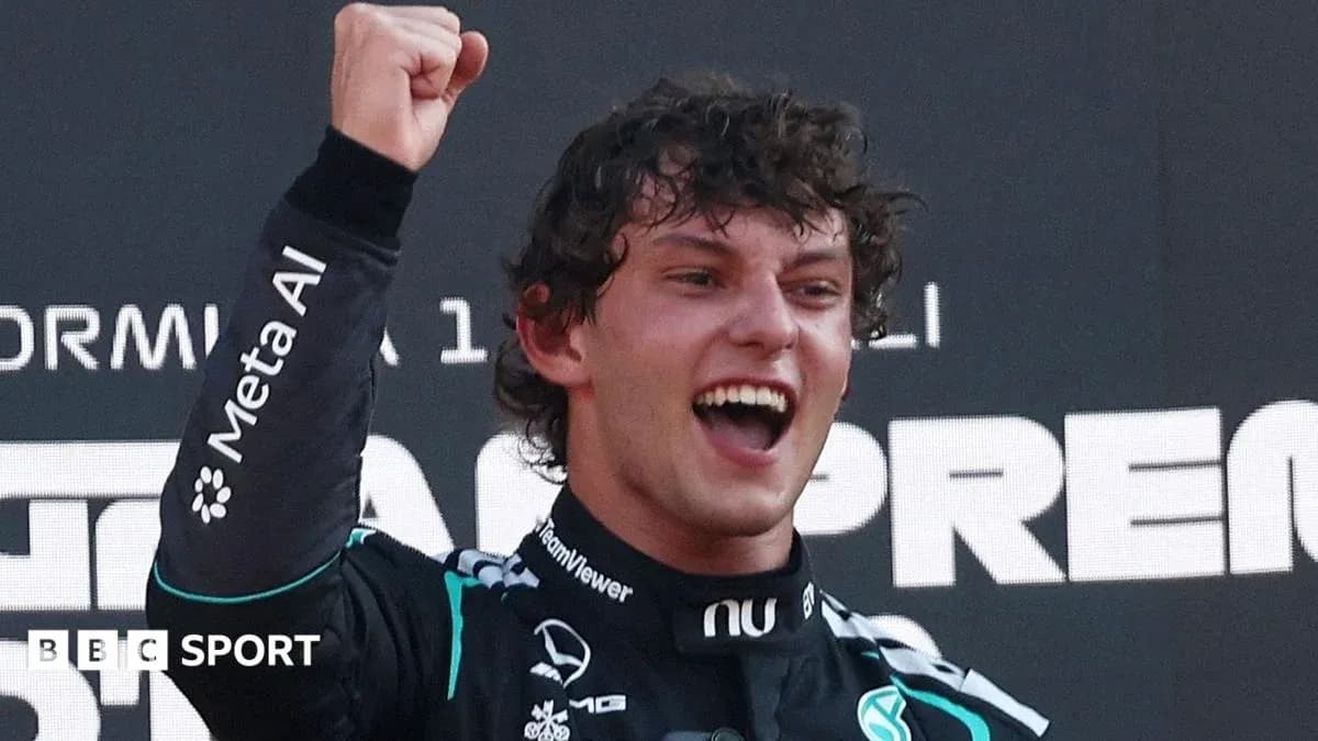 Driver celebrating victory on podium with raised fist