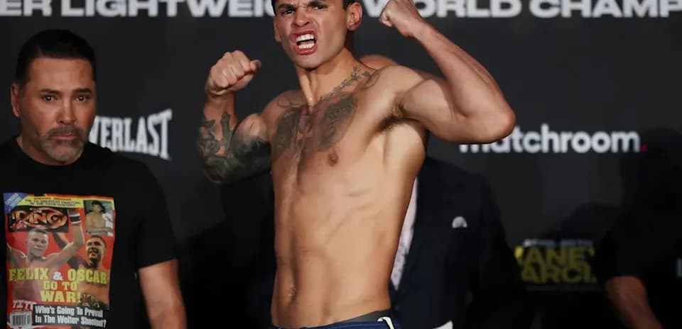 Fighter posing at weigh-in event with trainer nearby
