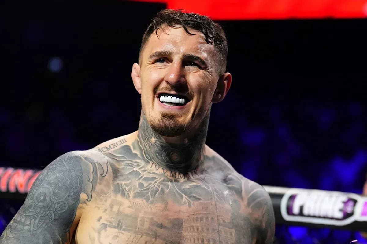 Boxer smiling in ring with tattoos visible
