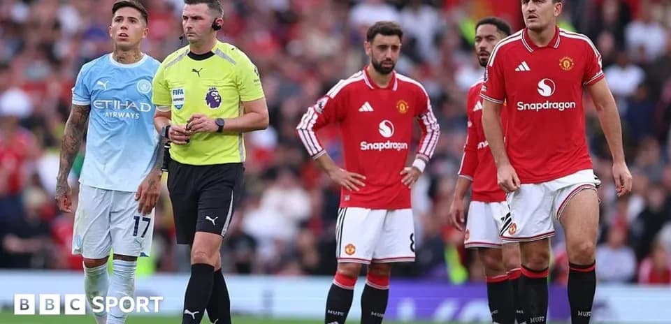 Players and referee during a Manchester derby match