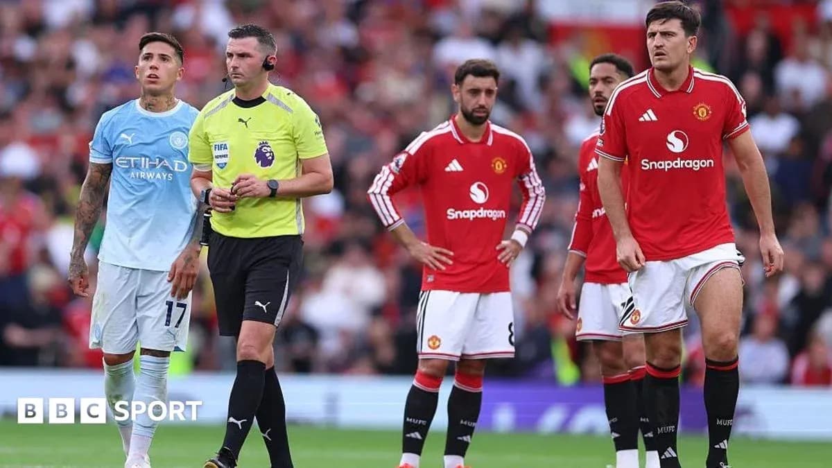 Players and referee during a Manchester derby match