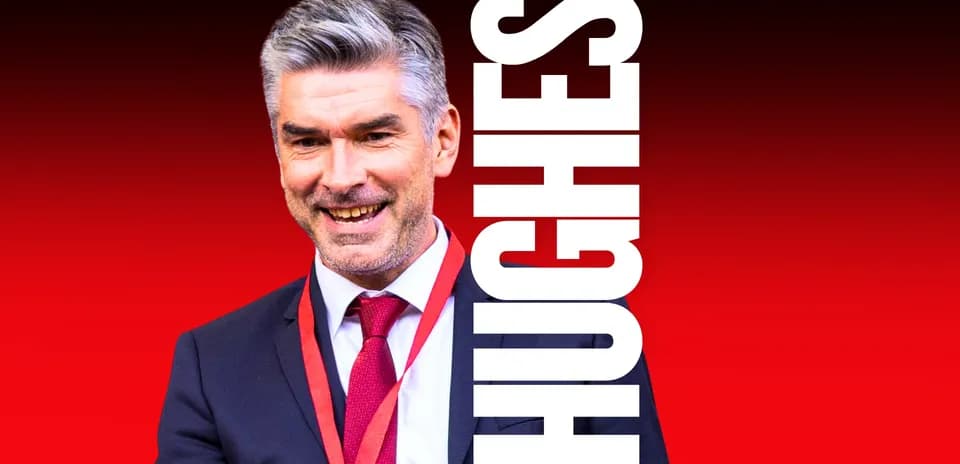 Man in suit smiling against red background