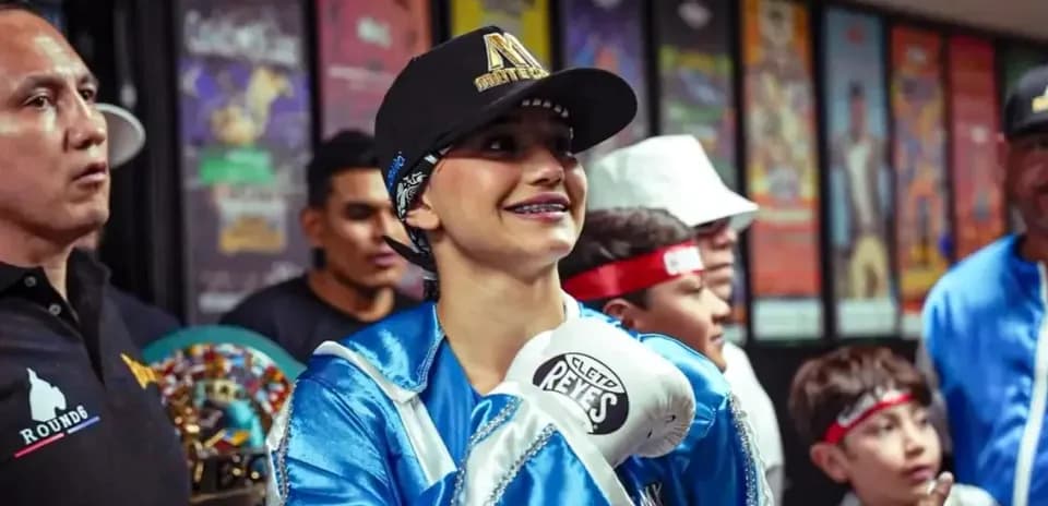 Female boxer in gloves smiling with supporters