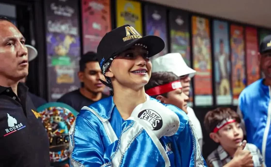 Female boxer in gloves smiling with supporters