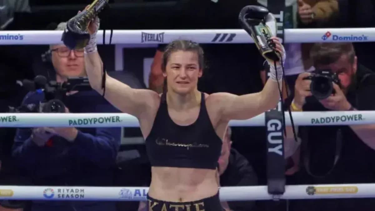 Boxer celebrating victory with gloves raised in ring