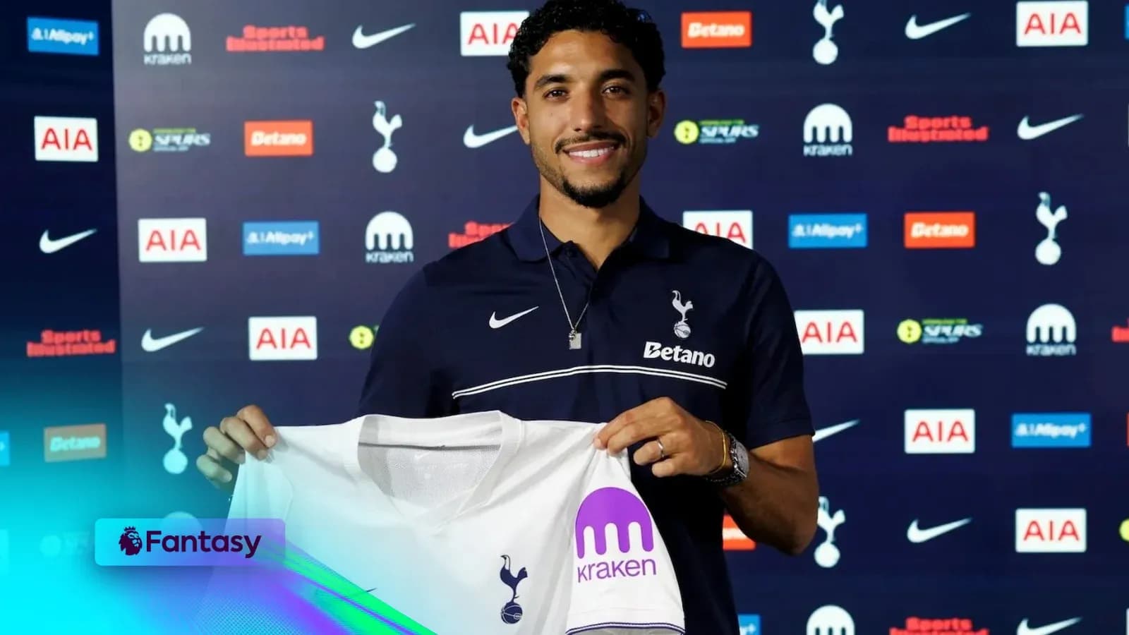 Player holding Tottenham jersey at signing event