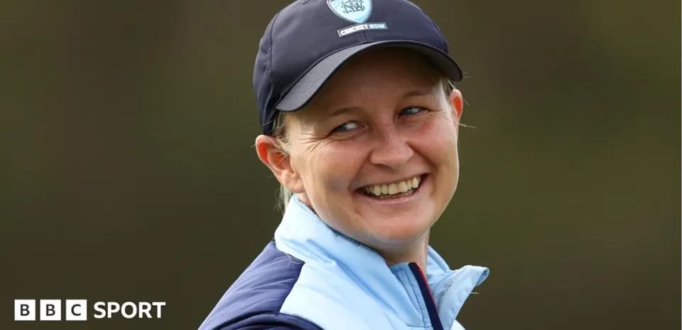 Smiling woman wearing a cricket cap outdoors
