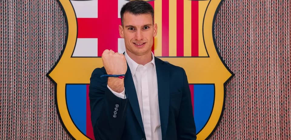 New player posing with FC Barcelona crest backdrop