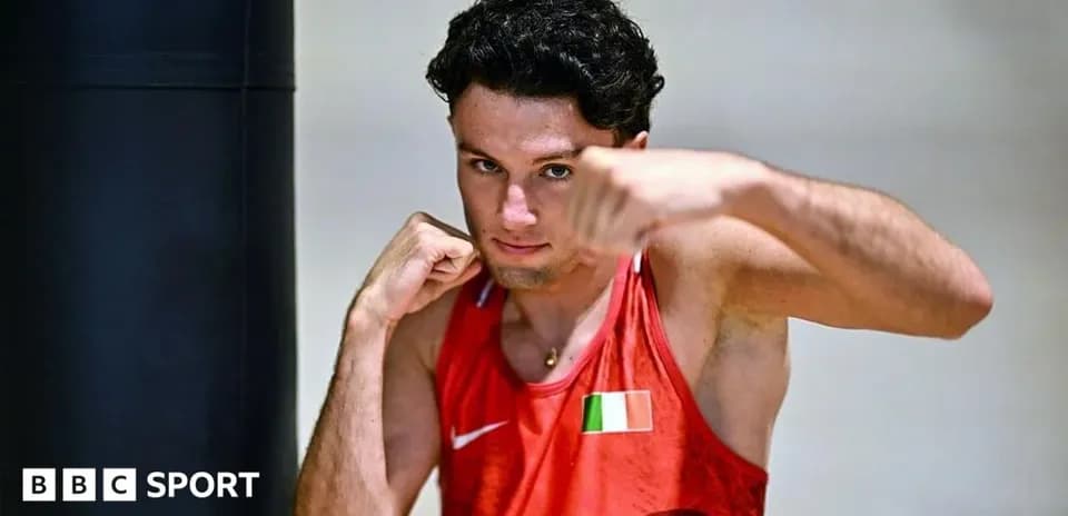 Boxer posing with fists raised in training gym