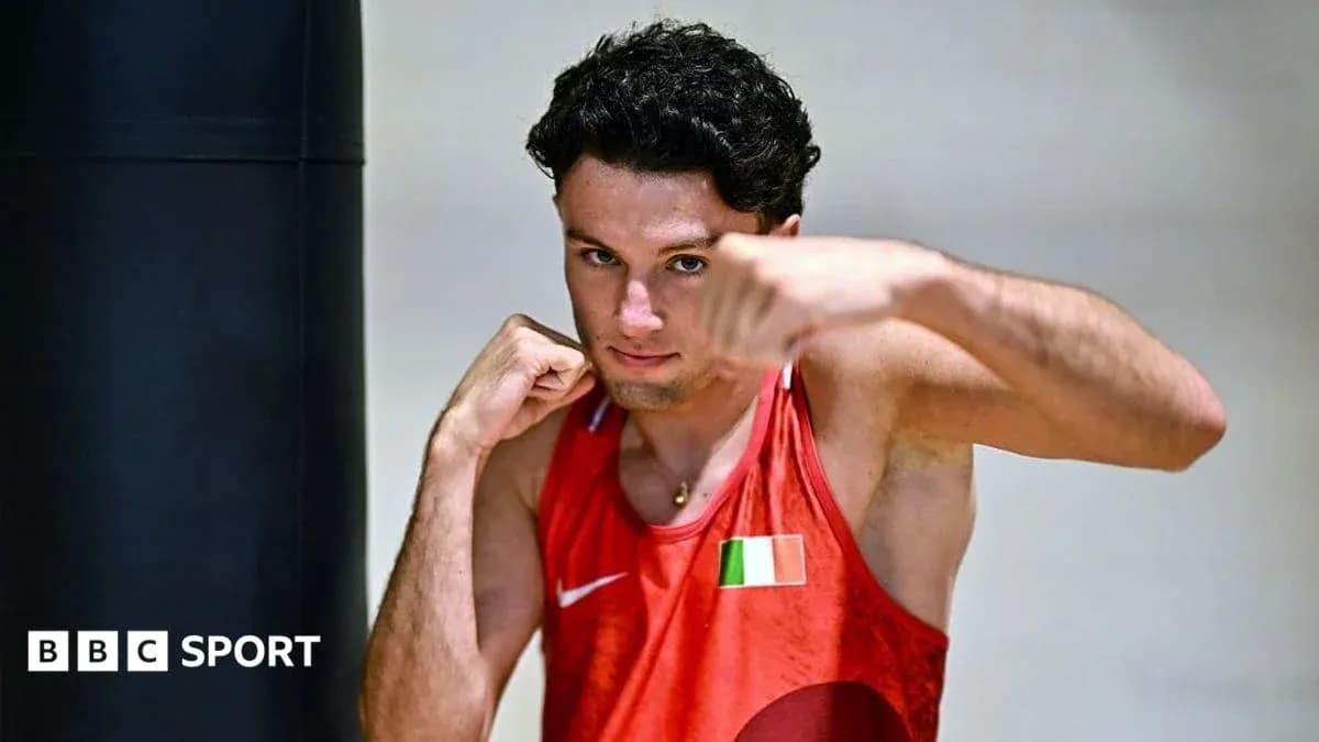 Boxer posing with fists raised in training gym