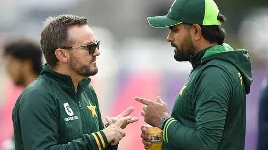 Two Pakistan team members discussing strategies on field