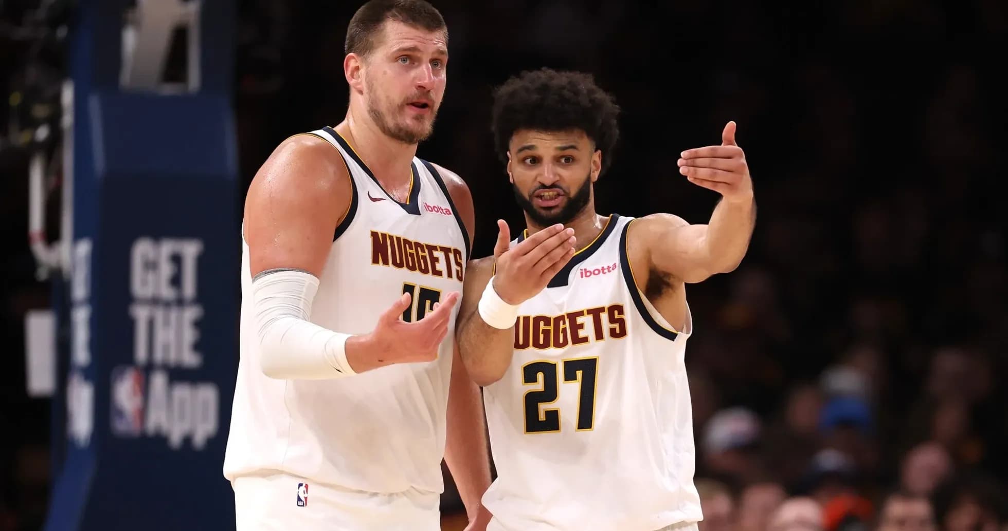 Two Denver Nuggets players discussing on the court