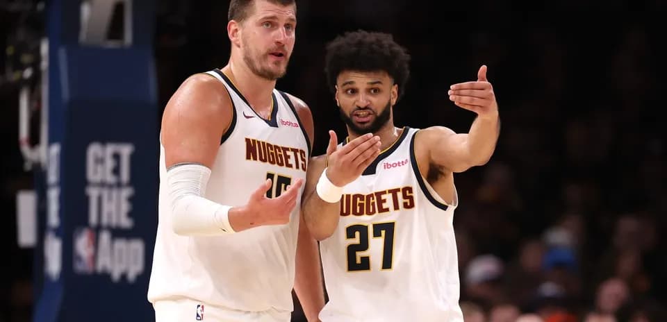 Two Denver Nuggets players discussing on the court