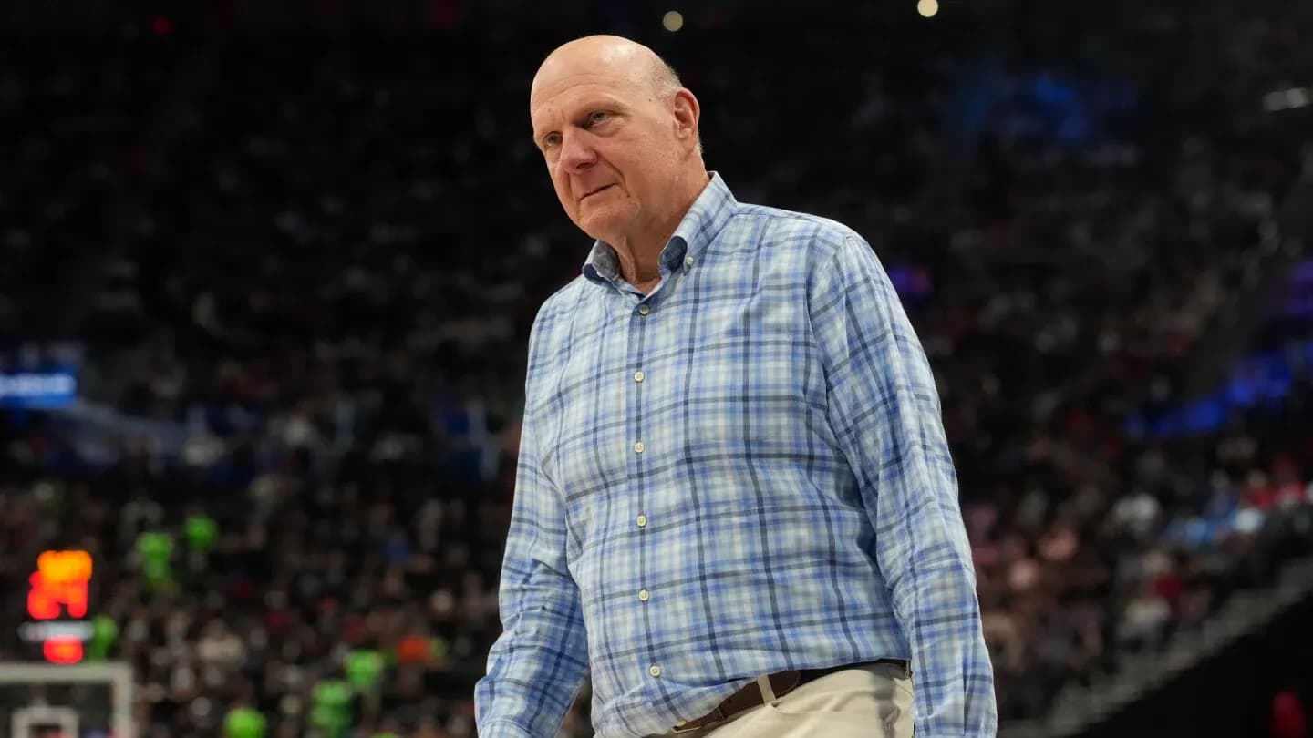 Man in plaid shirt on basketball court sidelines