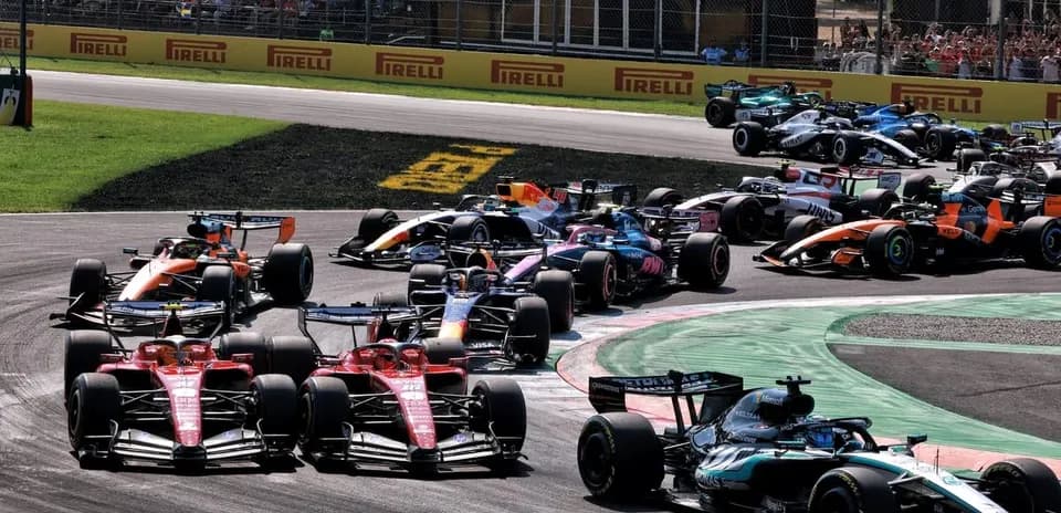 Multiple Formula 1 cars racing around a curve