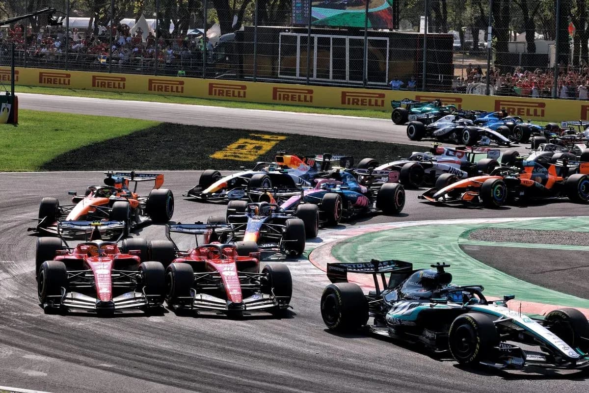 Multiple Formula 1 cars racing around a curve