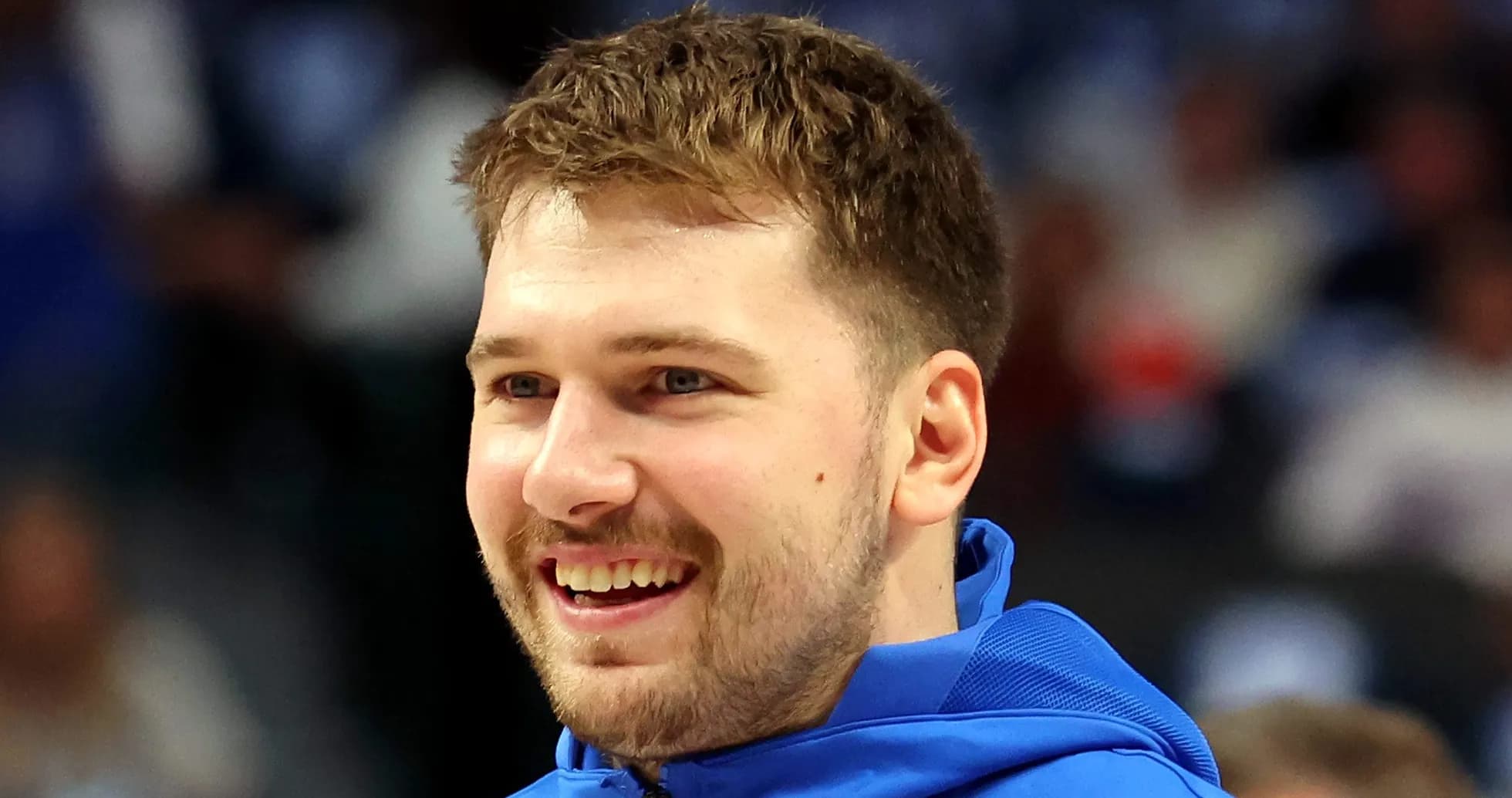 Player smiling while wearing team warm-up jacket