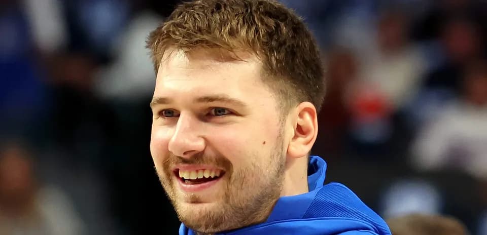 Player smiling while wearing team warm-up jacket