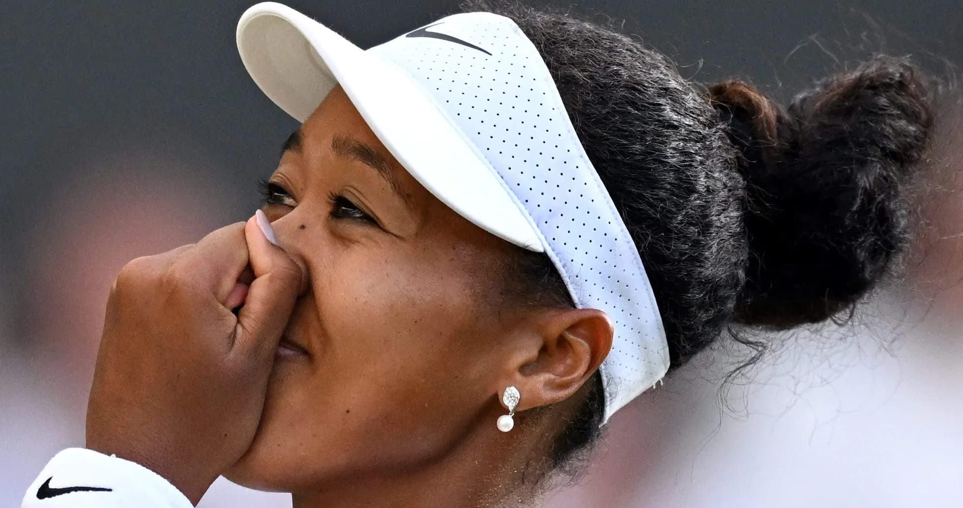 Naomi Osaka with hand on her face during match