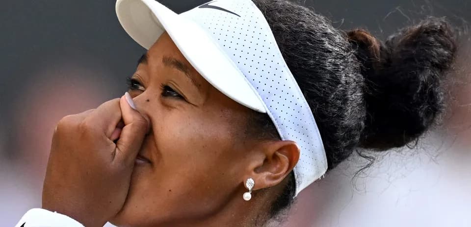Naomi Osaka with hand on her face during match