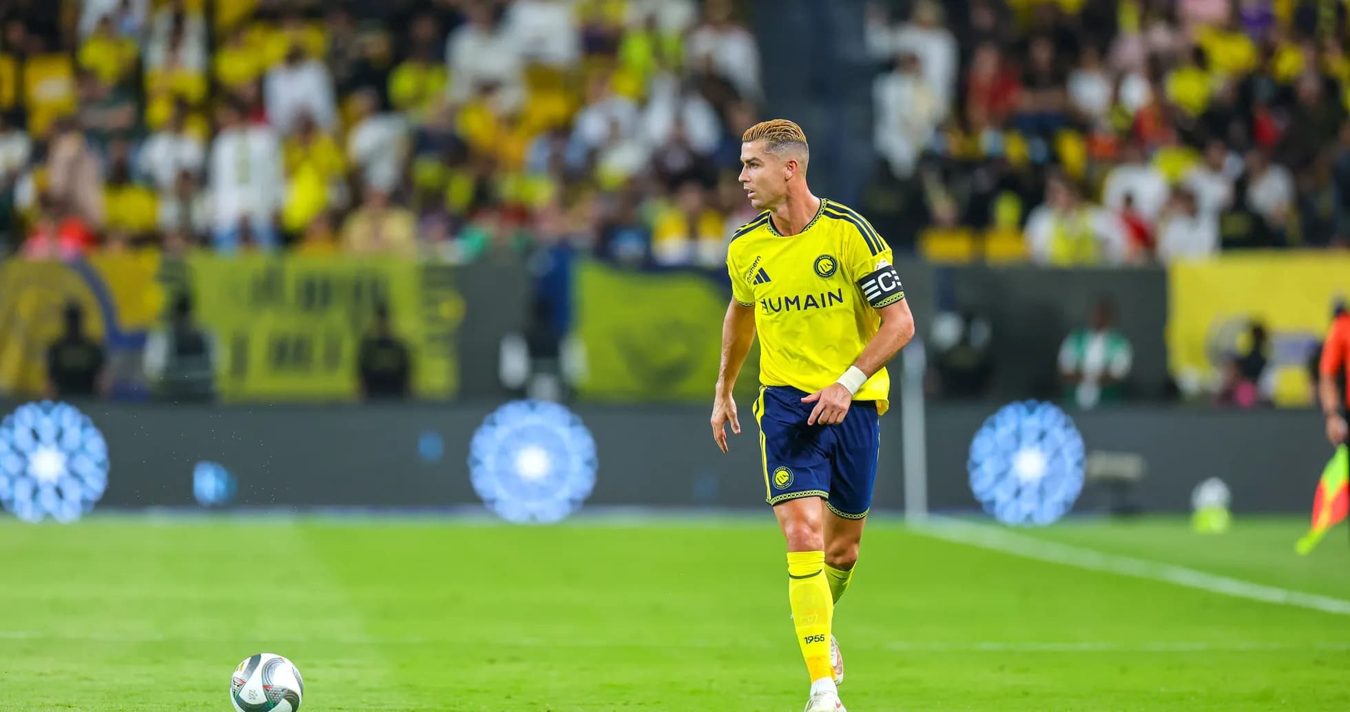 Player in yellow kit running with soccer ball