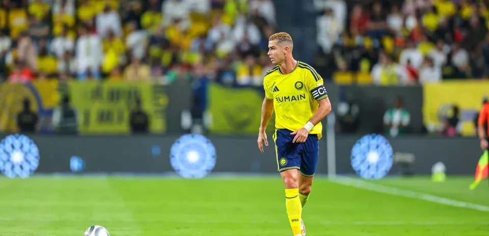 Player in yellow kit running with soccer ball