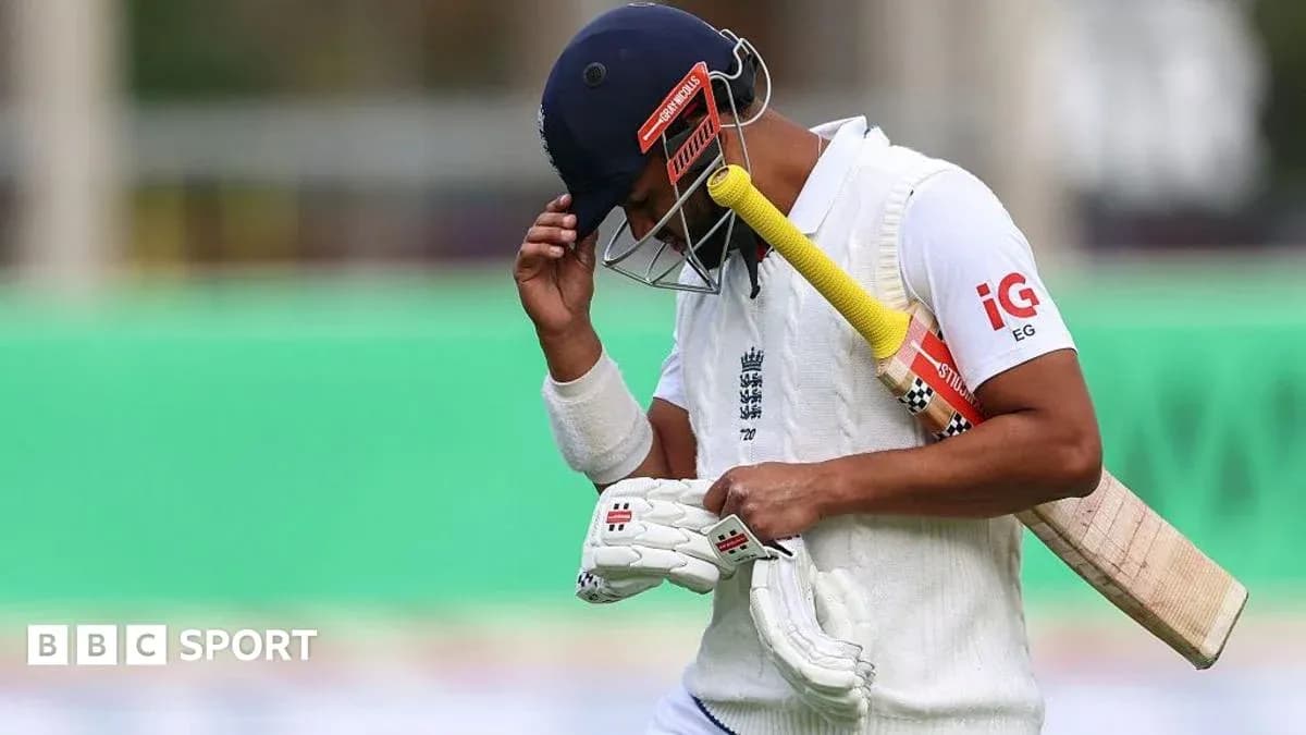 Cricketer walking off field with bat and gloves