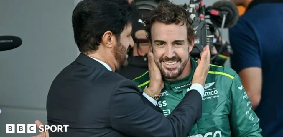 Two men interacting in a pit lane after race