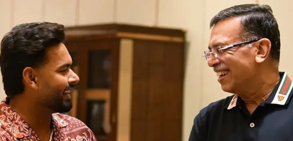 Two men smiling and engaging in conversation indoors