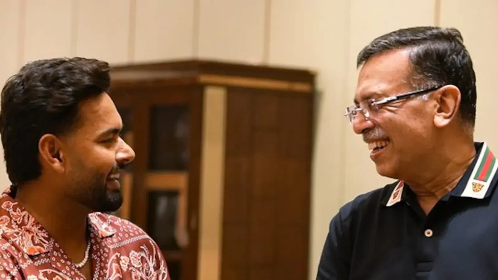 Two men smiling and engaging in conversation indoors