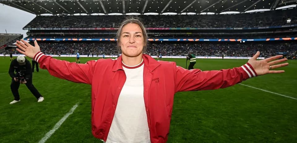 Woman in red jacket celebrating on football field