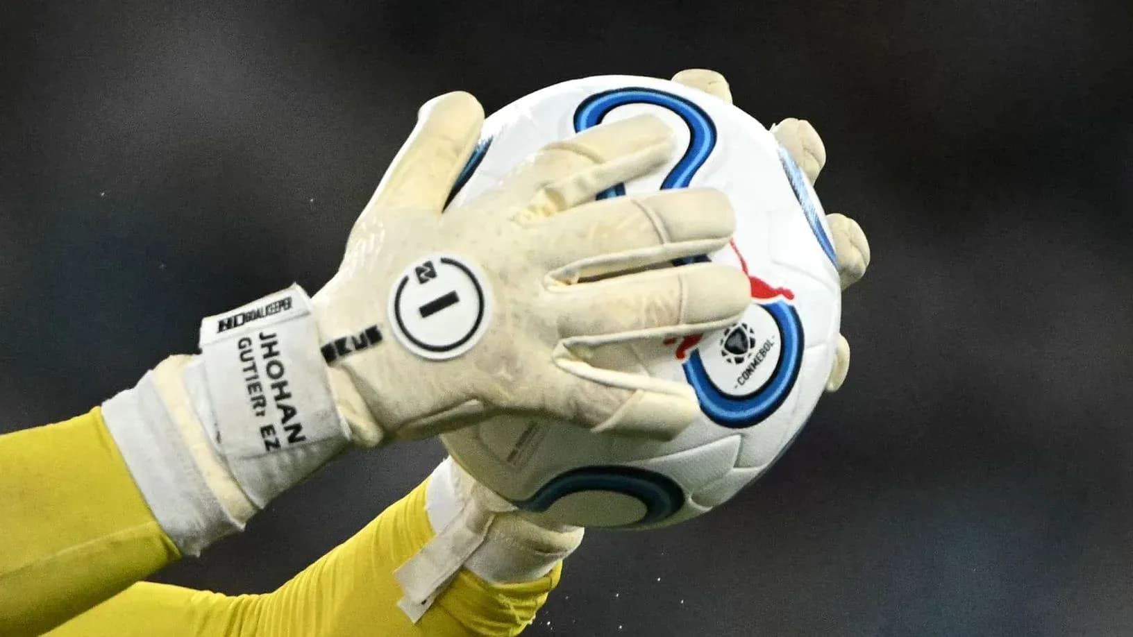 Goalkeeper catching a soccer ball in gloves