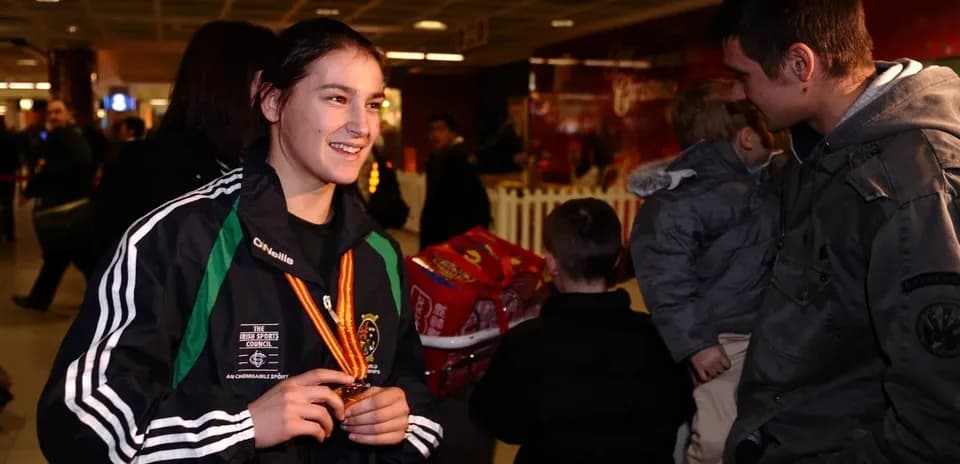 Athlete holding medal at an airport arrival area