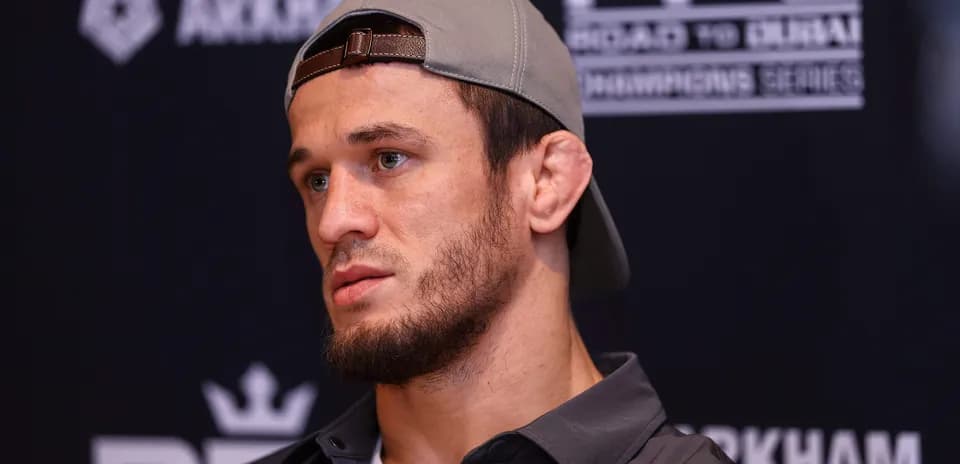 Fighter at press conference wearing cap and serious expression
