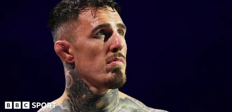 Fighter with tattoos looking up in the ring
