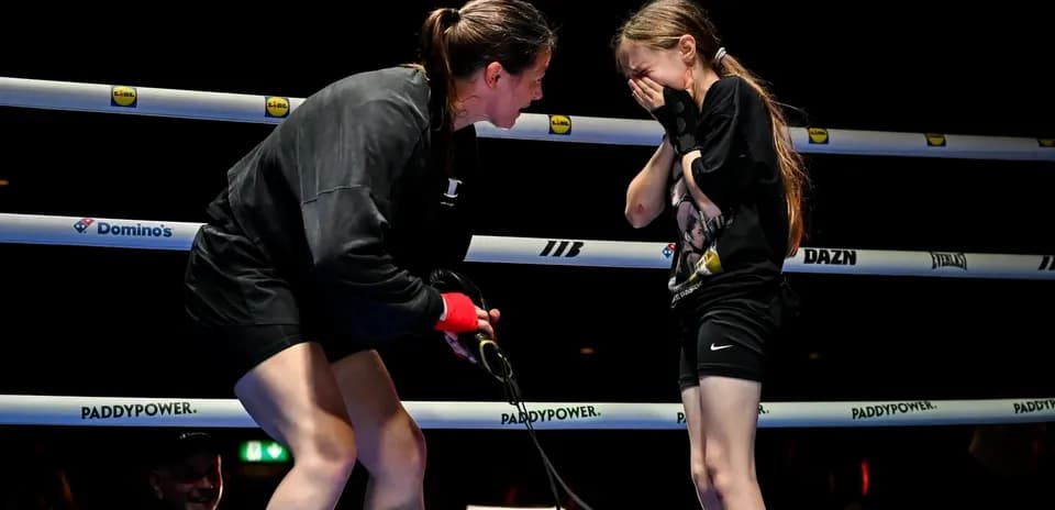 Boxer talking to young girl in ring