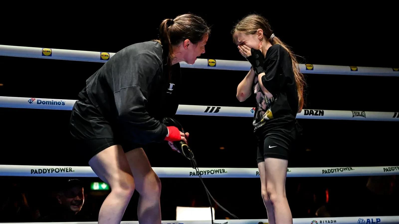 Boxer talking to young girl in ring