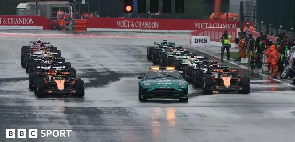 Formula 1 cars lined up under wet conditions