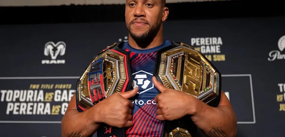 Fighter displaying multiple championship belts at event