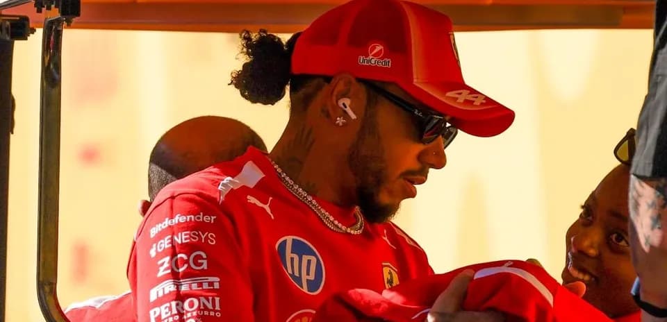 Driver in Ferrari uniform interacting with team members