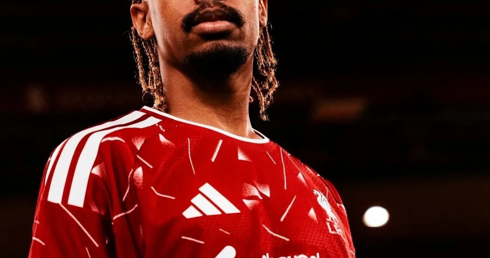 Player posing in red football jersey with logo