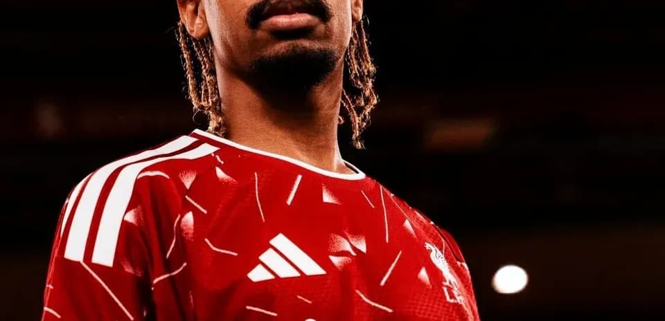 Player posing in red football jersey with logo