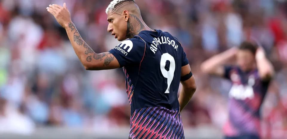 Player gesturing during match wearing team jersey
