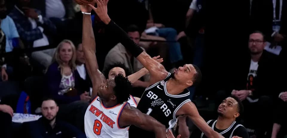 Player attempting to block shot during basketball game
